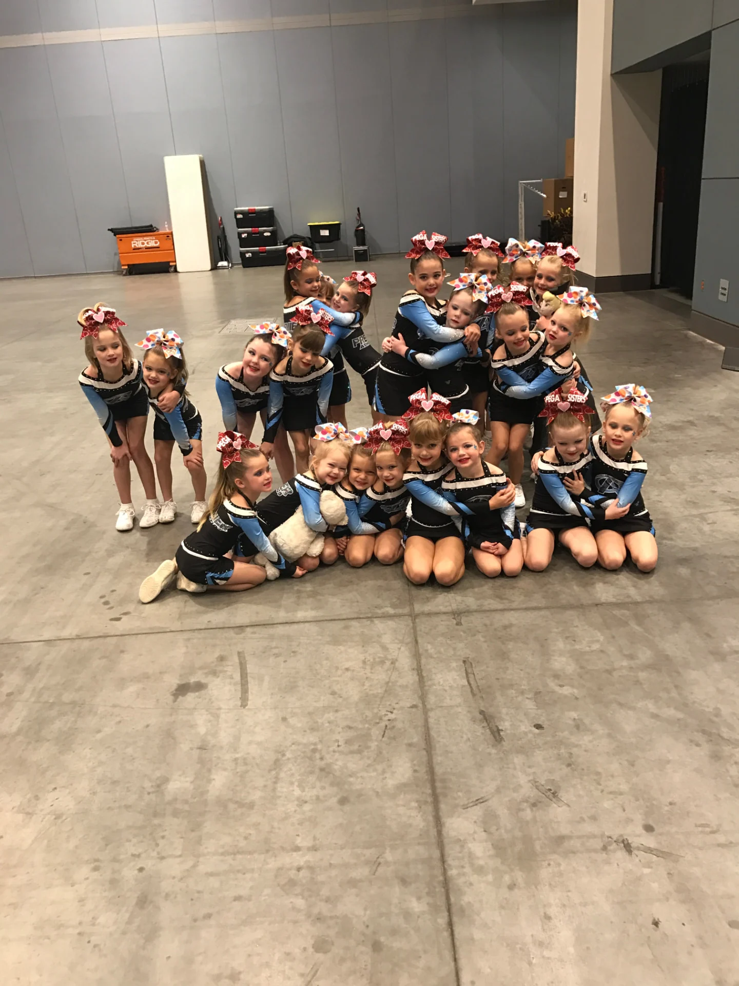 Tiny tots cheer team in blue and black uniforms